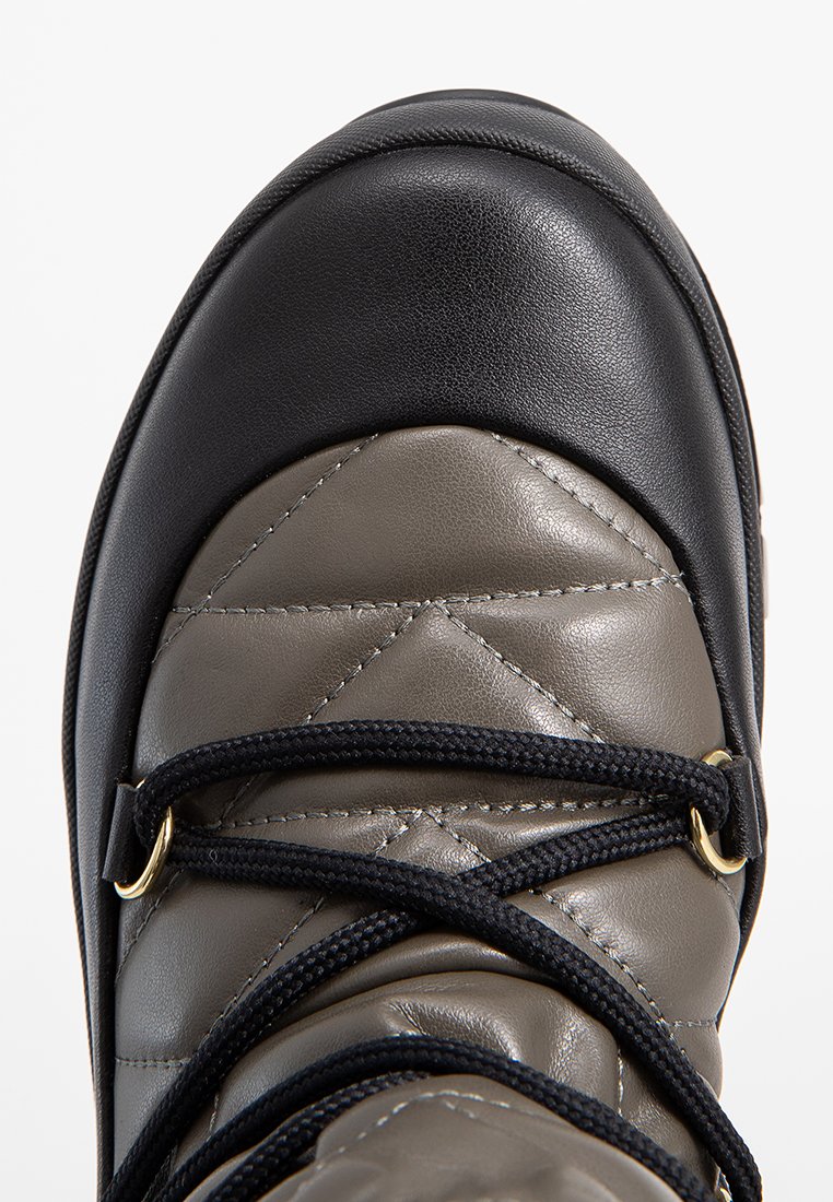 Braun- und schwarze Stiefel aus strukturiertem Leder mit gesteppten Mustern, schwarzen Schnürsenkeln und goldenen Hardware-Akzenten an den Ösen.