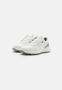 Baskets de sport blanches avec une tige en cuir lisse, des panneaux en mesh, une semelle en caoutchouc et des lacets élastiques. Présentent un léger accent gris au niveau du talon.