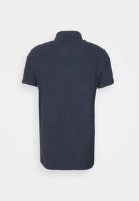 Polo bleu marine à manches courtes avec col, vu de dos sur fond blanc uni.