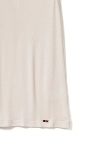 Korte mouwen beige ribbel top met een ronde halslijn en een klein merkteken aan de zoom. Zachte textuur, relaxed fit.