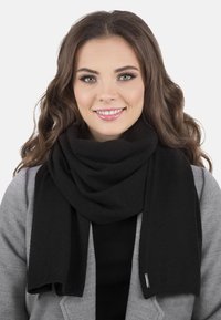 Șal negru dintr-un material moale, cu un design simplu și o textură plăcută. Șalul se așază elegant în jurul gâtului.