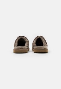 Brune suede slippers med blød, lys brun faux fur-fôr, åben hæl-design og holdbare gummisåler for komfort og greb.