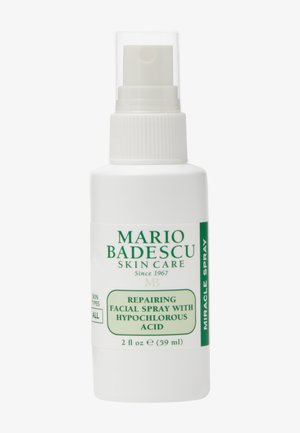 Witte sprayfles met het label "Mario Badescu Skin Care" met de tekst "Repairing Facial Spray with Hypochlorous Acid" en "Miracle Spray" in groene letters.