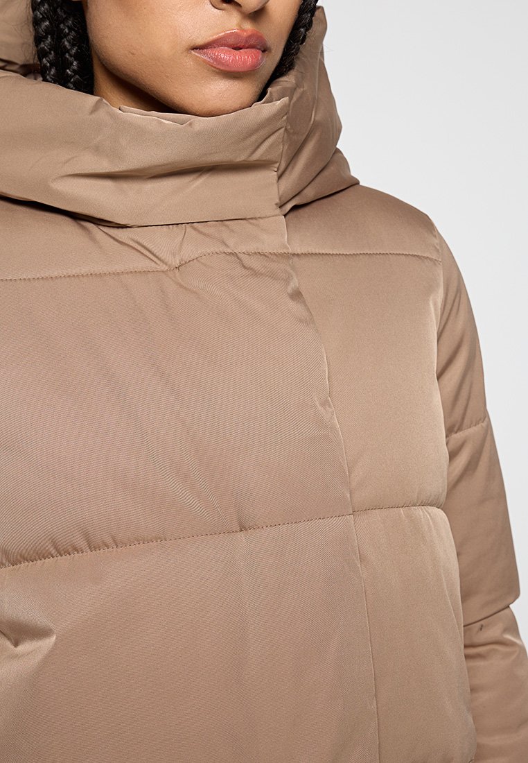 Chaqueta acolchada marrón con cuello alto y capucha, hecha de un tejido suave y liso, que presenta costuras horizontales y un diseño elegante.