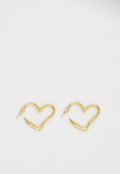 Gold hoop earrings shaped like hearts, featuring a sleek design with a curved texture and pointed ends for added detail.