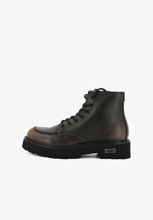 Stivale alla caviglia in pelle nera e marrone con lacci, suola in gomma spessa e logo del marchio in metallo sul tallone.