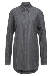 Svart-och-vit randig långärmad skjorta med knappstängning fram, krage och en enda bröstficka. Tillverkad av lättviktig tyg.