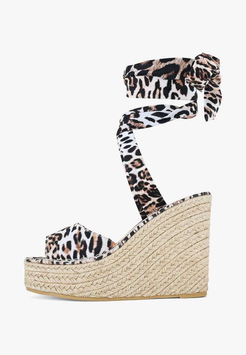 Sandalia cuña con parte superior de tela de leopardo, lazo en el tobillo y plataforma de yute trenzado. Presenta una puntera redondeada y suela texturizada para mayor agarre.