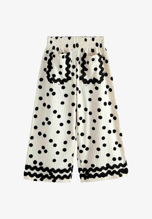 Bijele skraćene hlače s crnim točkicama, elastičnim pojasom, dva stražnja džepa s crnim valovitim obrubom i odgovarajućim obrubom na rubu.