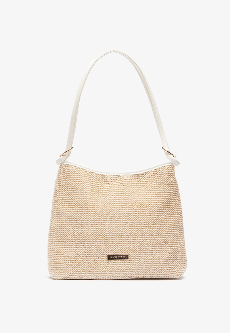 Beige woven handbag with a textured pattern, white strap, top trim, and a metallic logo accent on the front. Large and spacious design.