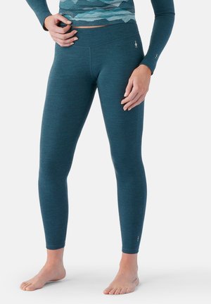 Teal leggings made of soft, textured fabric; fitted design; high waistband; small logo accent near the ankle; lightweight and flexible.