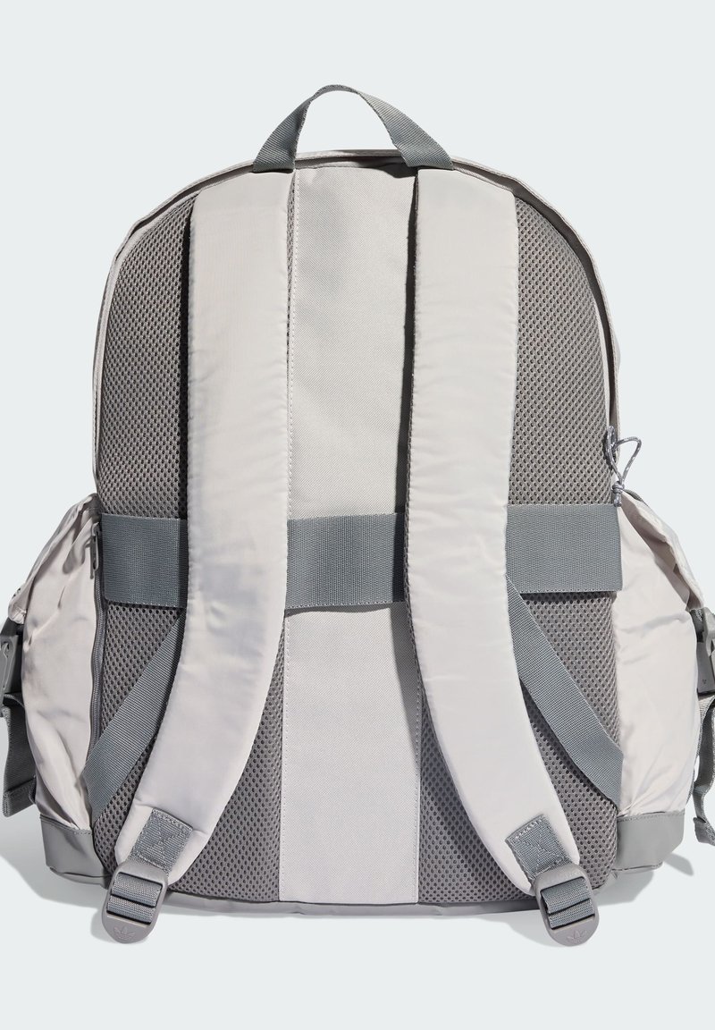 Lysegrå rygsæk med netpanel på bagsiden, polstrede stropper og sidelommer. Har justerbare stropper og logo-detaljer på metaldele.