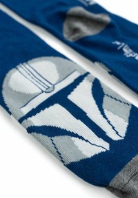 Calzini blu con un design grigio e bianco di un casco, realizzati in tessuto lavorato a maglia con una texture liscia e un polsino grigio a contrasto.