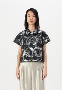 Camicia nera e argento a maniche corte con colletto e motivo astratto a onde. Il tessuto ha una texture lucida e una vestibilità comoda.