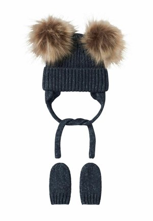 Dunkelblauen Strickmütze mit zwei hellbraunen Kunstfell-Pompoms und Ohrenklappen, kombiniert mit passenden dunkelblauen fingerlosen Handschuhen.