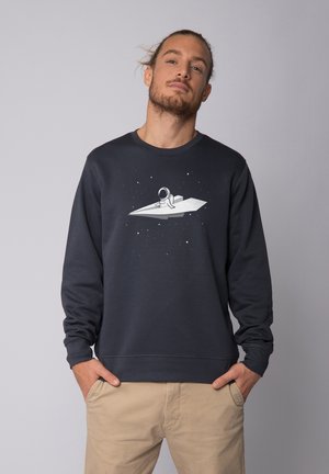 Marineblauwe sweatshirt met lange mouwen, voorzien van een afbeelding van een astronaut op een papieren vliegtuig omringd door sterren. Zacht materiaal, casual pasvorm.