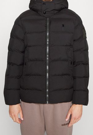 Schwarze Steppjacke mit Reißverschluss vorne, Kapuze und gesteppten Paneelen. Verfügt über ein Logo auf der Brust und der Schulter, mit einer eleganten, glatten Oberfläche.