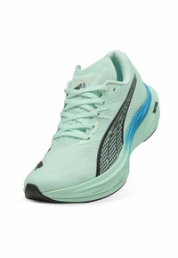Heller mintgrüner Laufschuh mit einem strukturierten Mesh-Obermaterial, schwarzen und blauen Akzenten, gepolsterter Ferse und Gummisohle mit ausgeprägtem Muster.