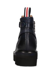 Bota de cuero azul marino hasta el tobillo con un tacón ancho, detalle de hebilla y tirador a rayas; presenta perforaciones al estilo brogue y una textura suave.