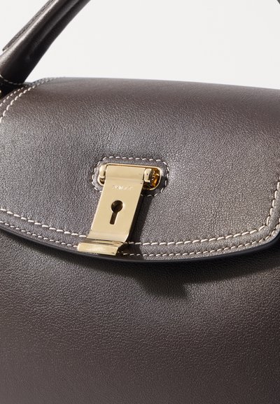 Brown leather handbag featuring a gold-tone clasp and stitching accents. The surface has a smooth texture with a structured design.