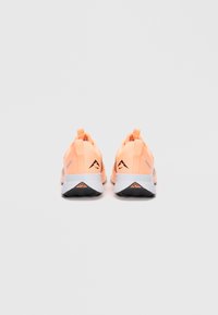 Chaussures de sport au design léger et respirant ; tissu orange vif, accents gris, languettes au niveau des talons et semelles blanches avec un profil noir.
