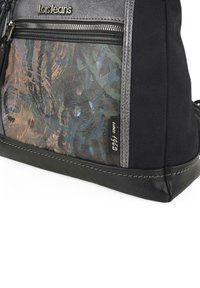 Bolsa tote negra y gris con un diseño texturizado, que presenta un panel frontal con patrones, herrajes de plata y un detalle del logo en el borde superior.