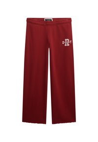 Rode wijde sweatpants van zacht materiaal, met een elastische tailleband en witte bedrukte tekst op het linkerpijp.
