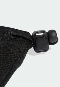 Accessorio in tessuto nero con finitura testurizzata, dotato di blocco a cordoncino e meccanismo a cursore per la regolazione.