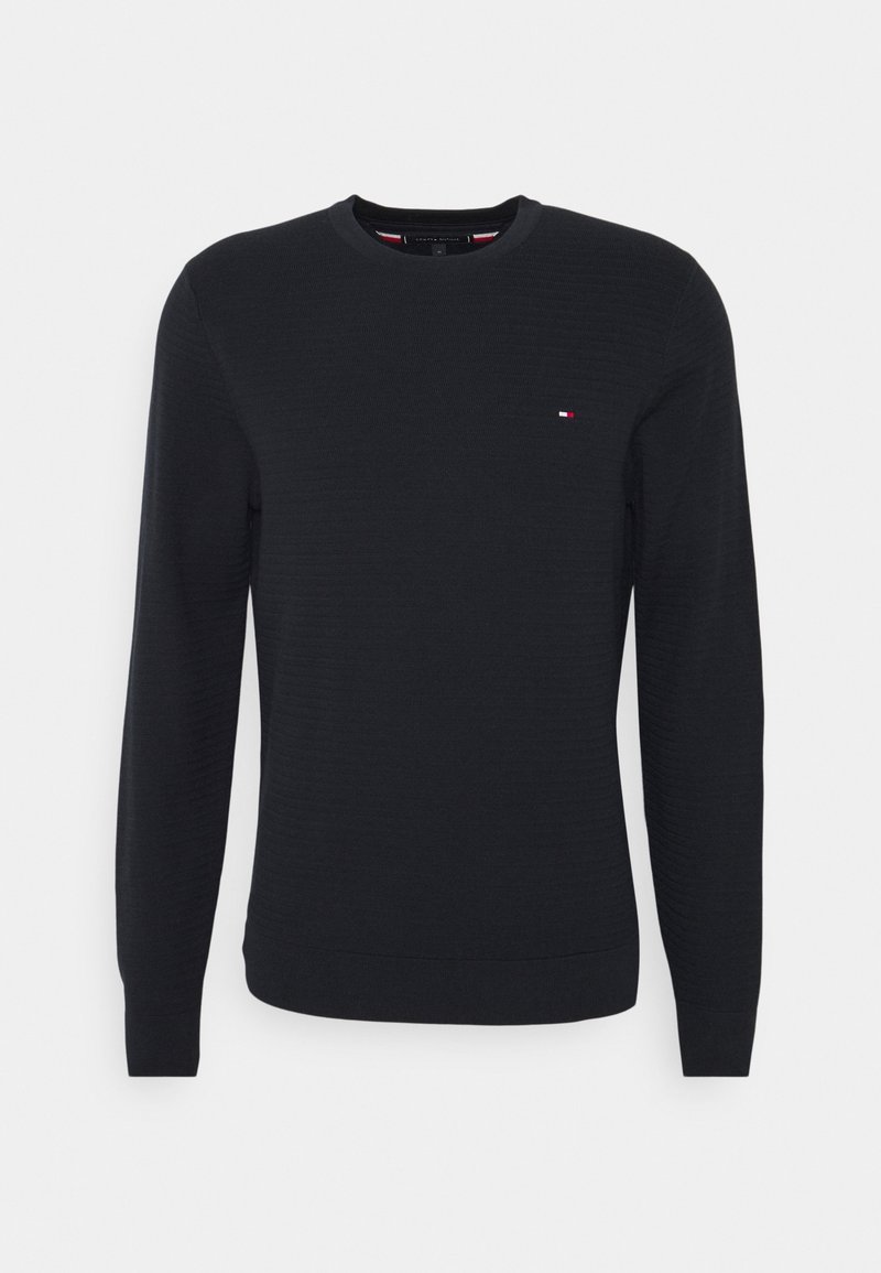 Pull noir à manches longues avec col rond et petit logo rectangulaire rouge, blanc et bleu sur la poitrine gauche.