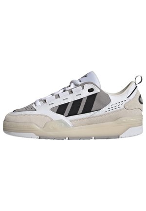 Lav-sko sneaker i hvid, grå og sort med ruskind og mesh paneler, snørelukning og en tyk beige sål.