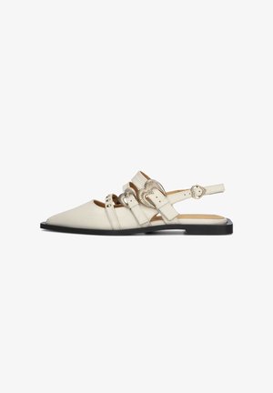 Slingback sandalen in lichtcrème leer met een puntige neus, decoratieve metalen accenten en verstelbare banden op een zwarte platte zool.