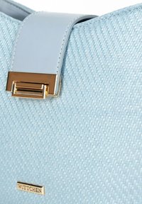 Sac à main bleu clair avec une texture tissée, arborant une bandoulière lisse bleu clair et des finitions en métal doré avec un fermoir rectangulaire.
