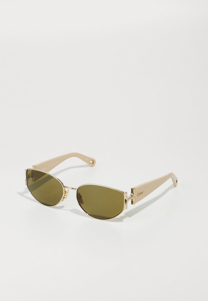 Gafas de sol doradas con lentes ovalados alargados y tono verde, con brazos de acetato beige que presentan una marca grabada.