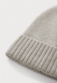 Grey knit beanie with ribbed cuff, soft texture, and rounded top. Material appears wool or similar. Close-up view focused on the edge.