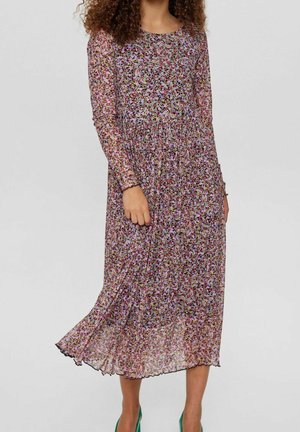 Kwiecista sukienka maxi z przezroczystej tkaniny, z długimi rękawami, marszczonym stanem oraz kolorowym wzorem fioletowych, różowych i żółtych kwiatów, z falbaną na dole.