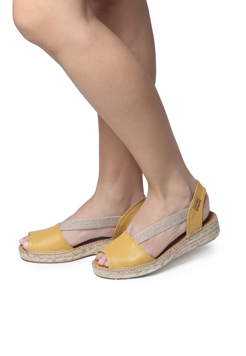 Sandali espadrillas in pelle gialla con design open toe, cinturini elastici e suola avvolta in juta per texture e comfort.