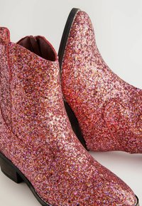 Bottines à paillettes dans des teintes roses et rouges, avec un bout rond, un petit talon empilé et couvertes de sequins scintillants pour une finition texturée.