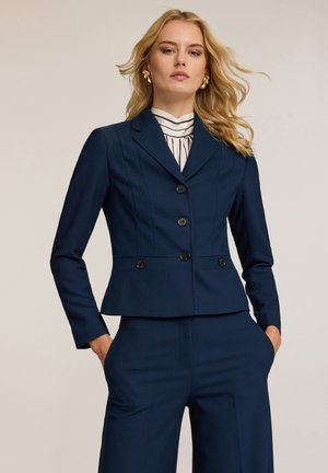 Navyblauwe blazer met een getailleerde snit, een enkele knoopsluiting, twee voorzakken en vier zwarte knopen. Lichtgewicht stof met een gladde textuur.