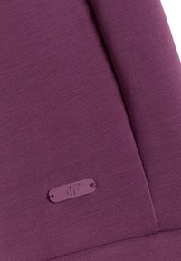 Gros plan d'un tissu violet plié avec une petite étiquette violette embossée "4F" cousue près du bord.