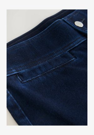 Dark blue denim fabric with subtle texture, featuring a stitched waistband and a small back pocket. Silver button accent on the front.