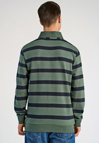 Pasekowana koszulka polo z długim rękawem, z ciemnozielonymi i granatowymi poziomymi paskami, kołnierzykiem i mankietami na ściągaczu. Miękka, teksturowana tkanina.