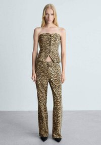 Set od dva dijela sa uzorkom leoparda, koji se sastoji od topa bez naramenica s izrezom sprijeda i hlača visokog struka. Izrađen od laganog materijala s glatkom teksturom.