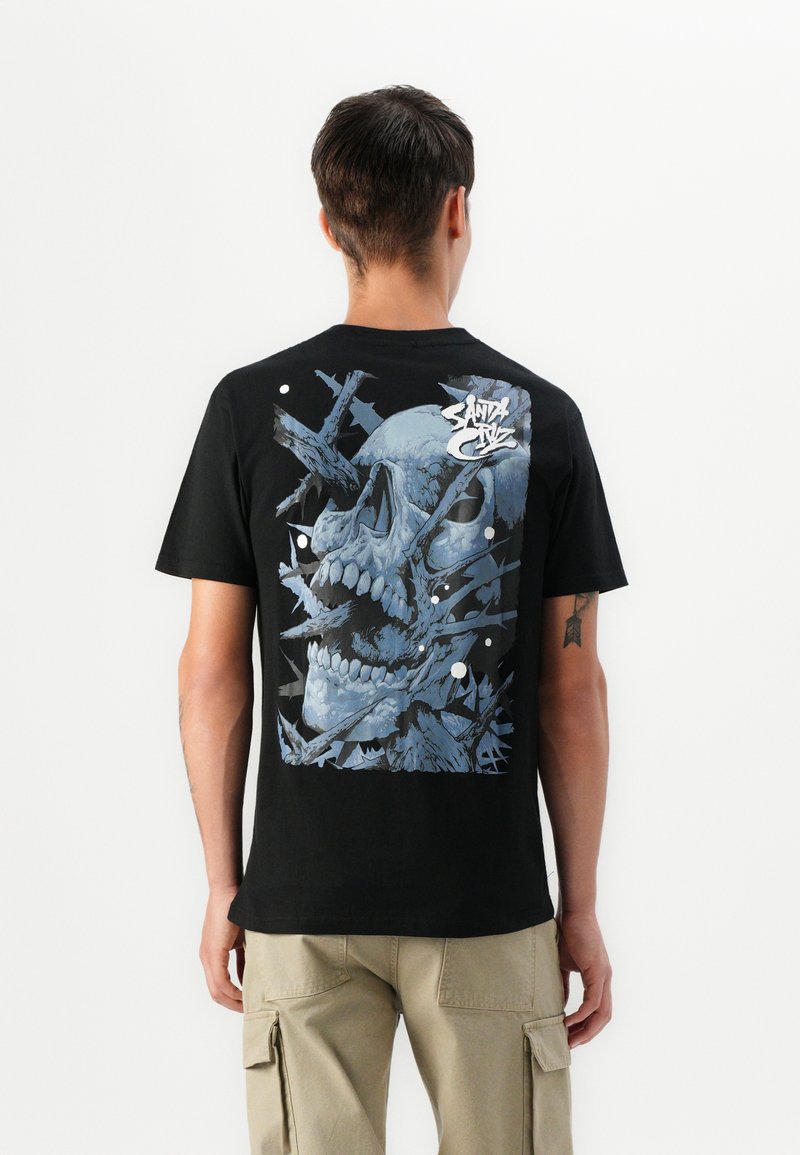 Zwart katoenen t-shirt met een blauwe schedelafbeelding op de achterkant, bestaande uit hoekige, gebroken vormen en abstracte witte accenten. Korte mouwen.