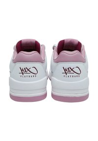 Balti sportiniai bateliai su lygiu paviršiumi, rožinės spalvos akcentai ant kulno ir pamušalo, su logotipu „K1X PLAYHARD“ bordo spalvos.