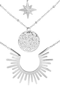 Collana a strati in argento con un charm a forma di stella, un pendente rotondo con texture e un design a raggi di sole allungati.