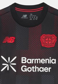 Maillot de sport noir avec accents rouges, présentant un motif texturé, le logo New Balance, le texte Barmenia Gothaer, et le blason du Bayer Leverkusen.