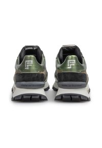 Två sportskor med en metallisk grön ovandel och svarta mockadetaljer, strukturerad gummisula och reflekterande logotyp på hälen.