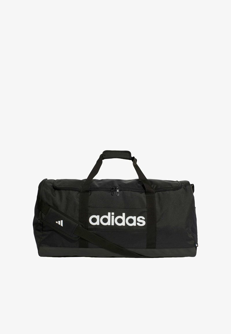 Čierna športová taška vyrobená z odolného textilu. Obsahuje biele logo Adidas, dvojité rúčky, nastaviteľný ramenný popruh a hlavnú komoru so zipsom.