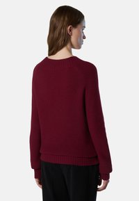 Maglione lavorato a maglia bordeaux con scollatura e polsini a costine, caratterizzato da una vestibilità comoda e una finitura testurizzata sul retro.