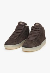 Brązowe zamszowe sneakersy za kostkę o teksturowanym wykończeniu, z grubymi brązowymi sznurowadłami i przezroczystą podeszwą. Logo marki na języku.
